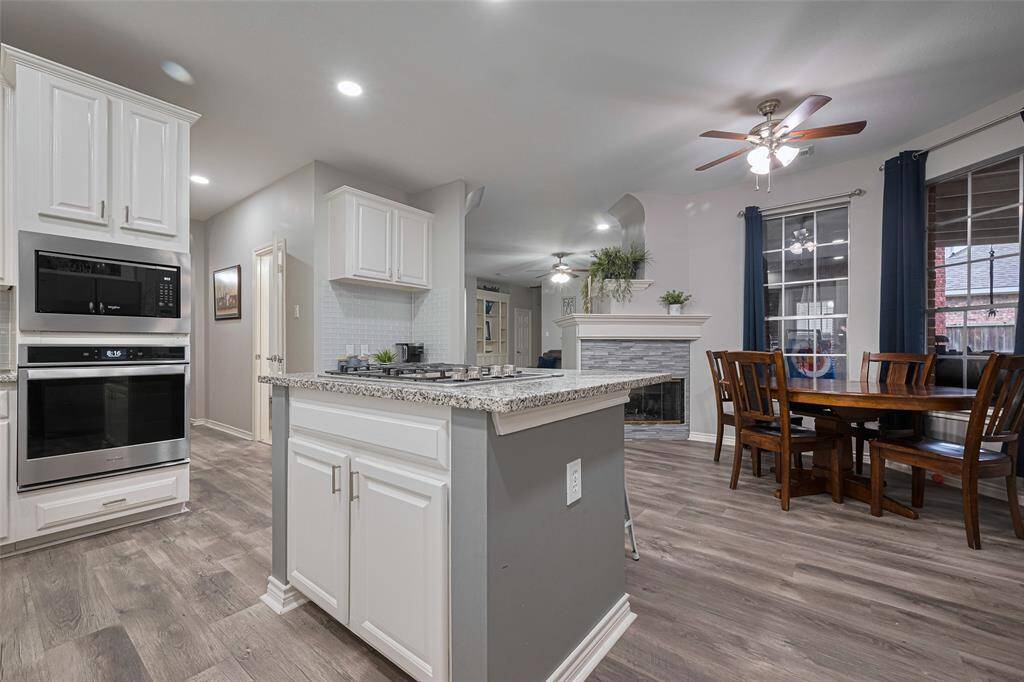 from this angle you can see the breakfast area to the right and at the back, the two-sided fireplace that opens into the living area.  Down the hallway to the left is the half bath, walk-in pantry and laundry room.