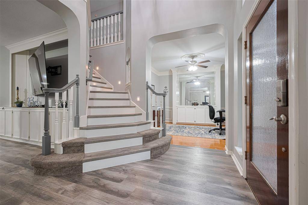 As you enter thru the frosted full-glass front door, you'll step onto modern wood-plank flooring that runs thru-out the living and kitchen areas. In the rear of this photo, you see the dining room- currently being used as an office traditional wood flooring.