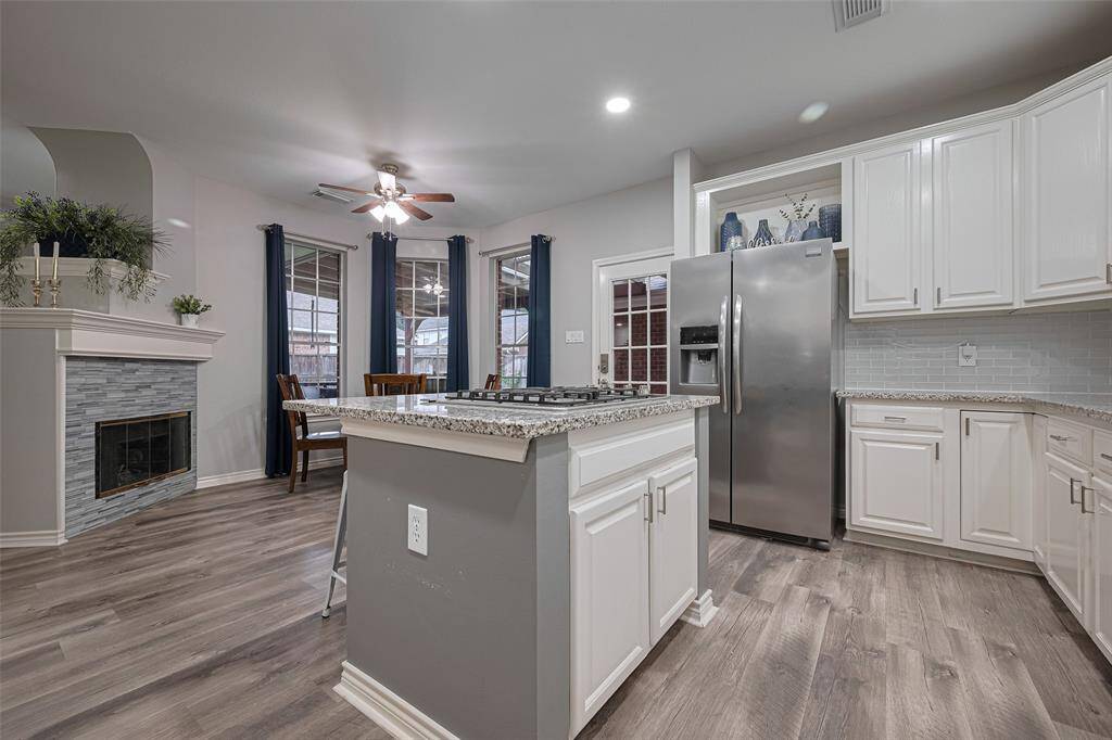 The kitchen island is home to a updated gas cooktop and also functions as a seating area.  Notice the abundance of cabinet and counter space in this kitchen.