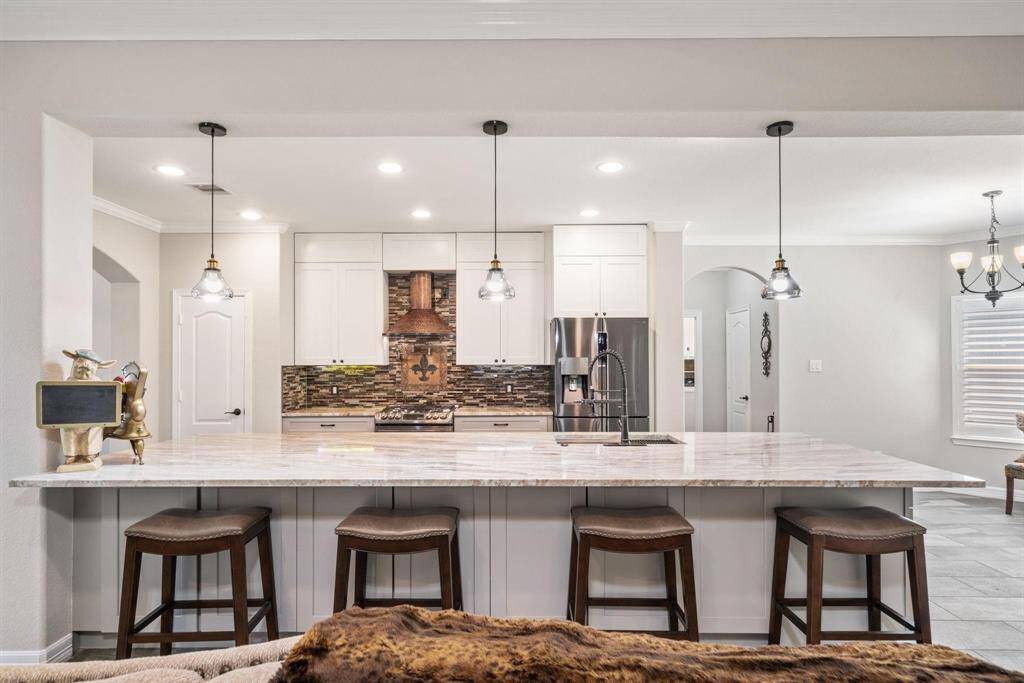 Pendant lights highlight the oversized island, which doubles as a stylish breakfast bar for casual meals.