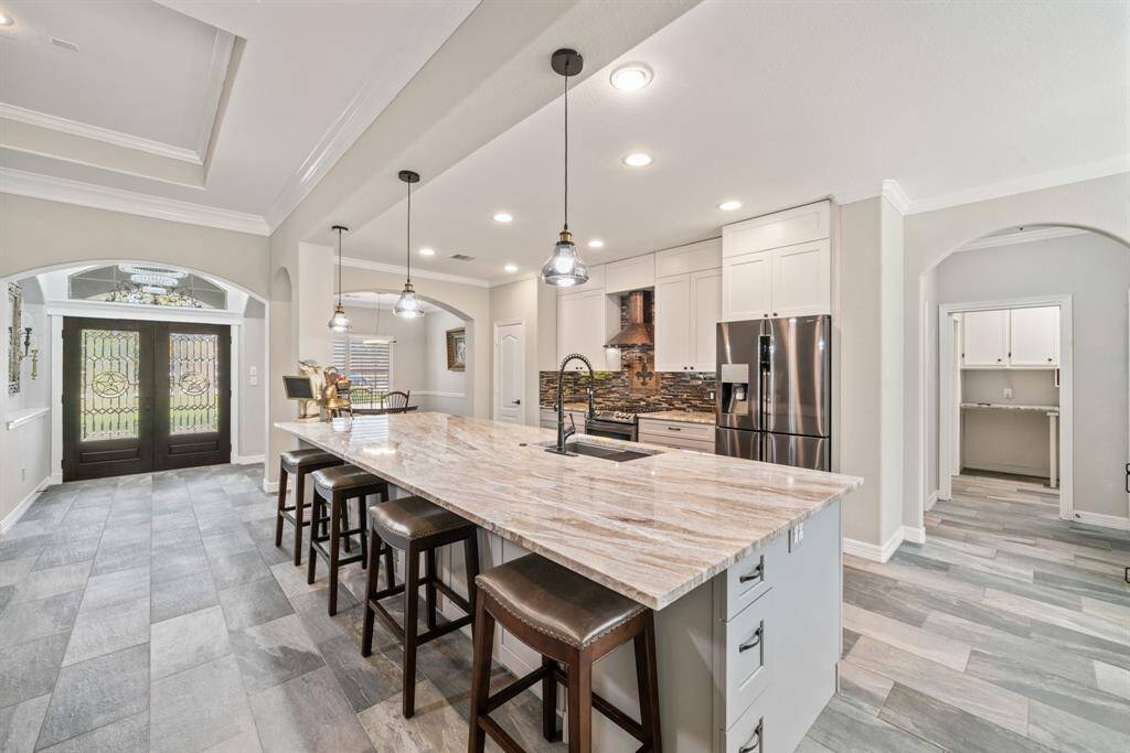 Recessed lighting illuminates the workspace, while the island sink and smart layout make this kitchen as functional as it is striking.
