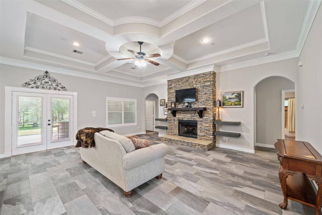 The recesses on the ceiling add architectural interest, while double glass-paneled doors open to the outdoors, blending indoor and outdoor living.