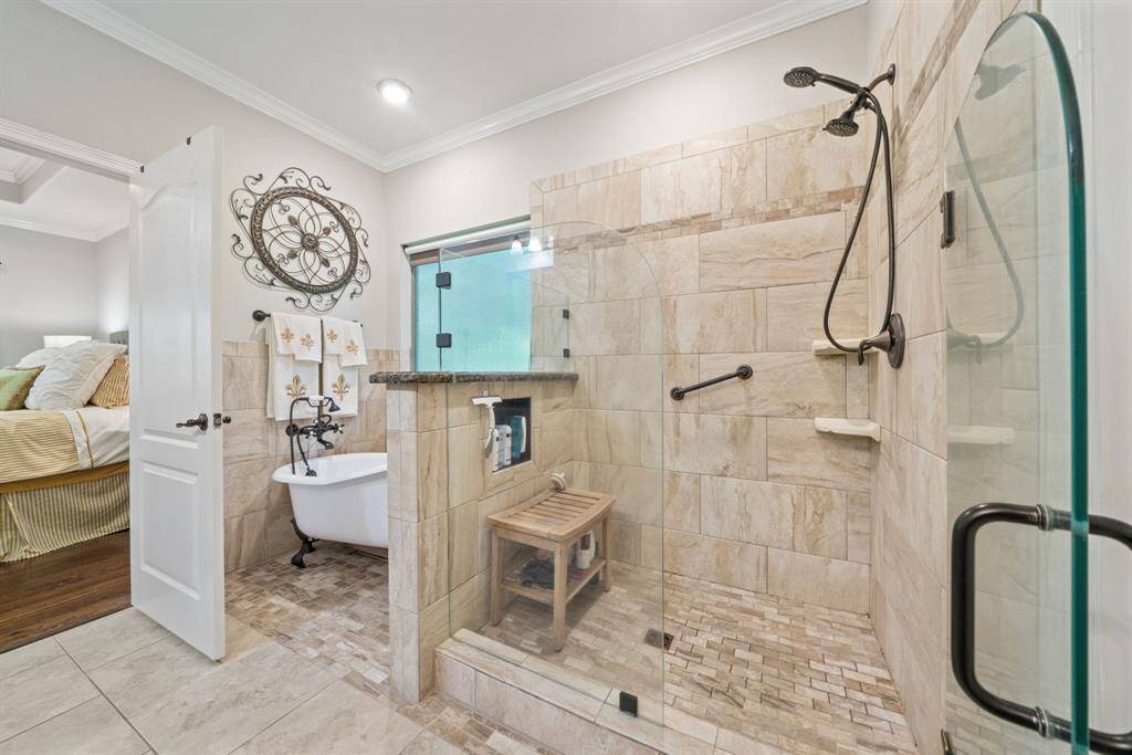 A soaking tub and a separate tiled shower offer spa-like comfort in this beautifully appointed primary en suite.