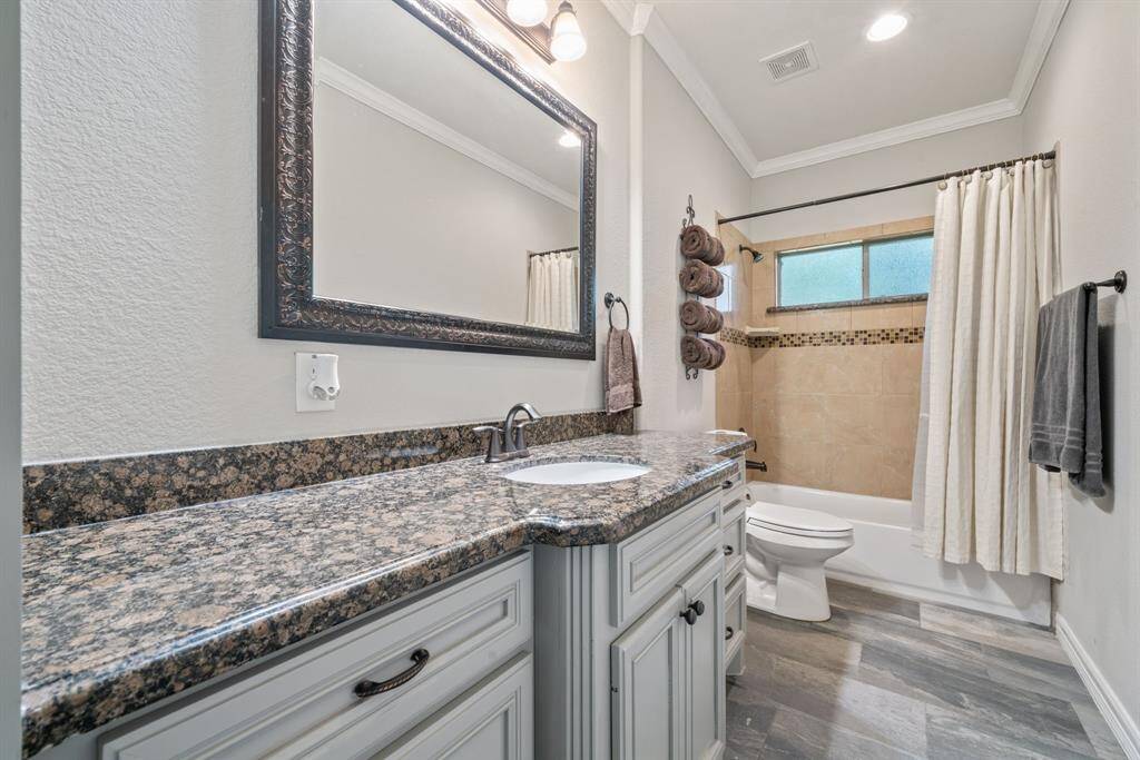 A spacious vanity and tub/shower combination offer flexibility and comfort in this well-appointed full bathroom.