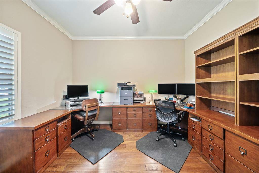 An expansive desk defines this room currently being used as a home office, which easily accommodates dual workstations and includes shelving and storage galore.