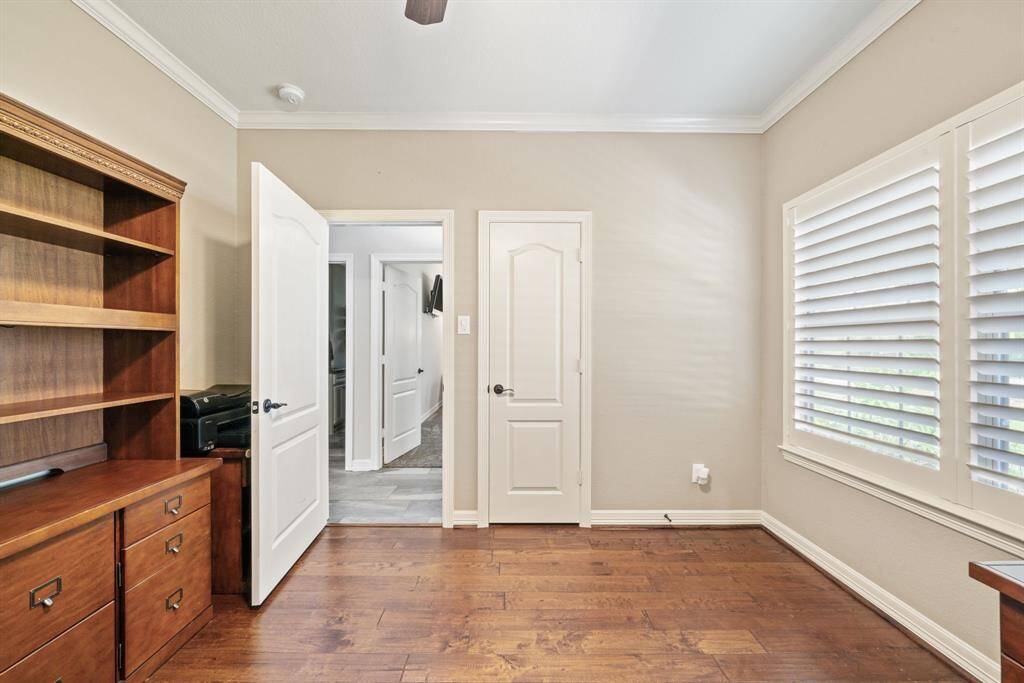 This room features large windows and wood floors that echo the built-ins—creating a refined yet productive space.