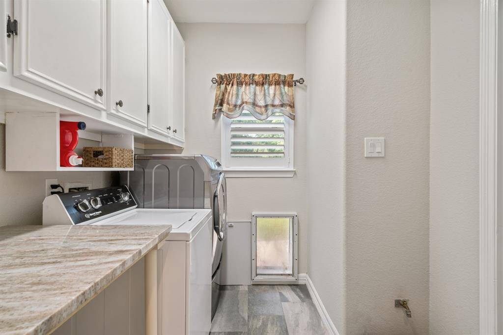 Sleek overhead cabinets and counter space provide efficiency and organization in the well-equipped laundry room.