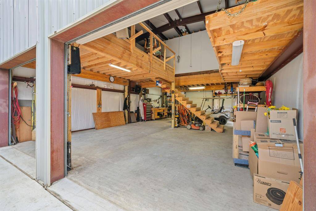 Inside the workshop, a wide-open space and upper loft provide unmatched versatility for work, storage, or creative pursuits.