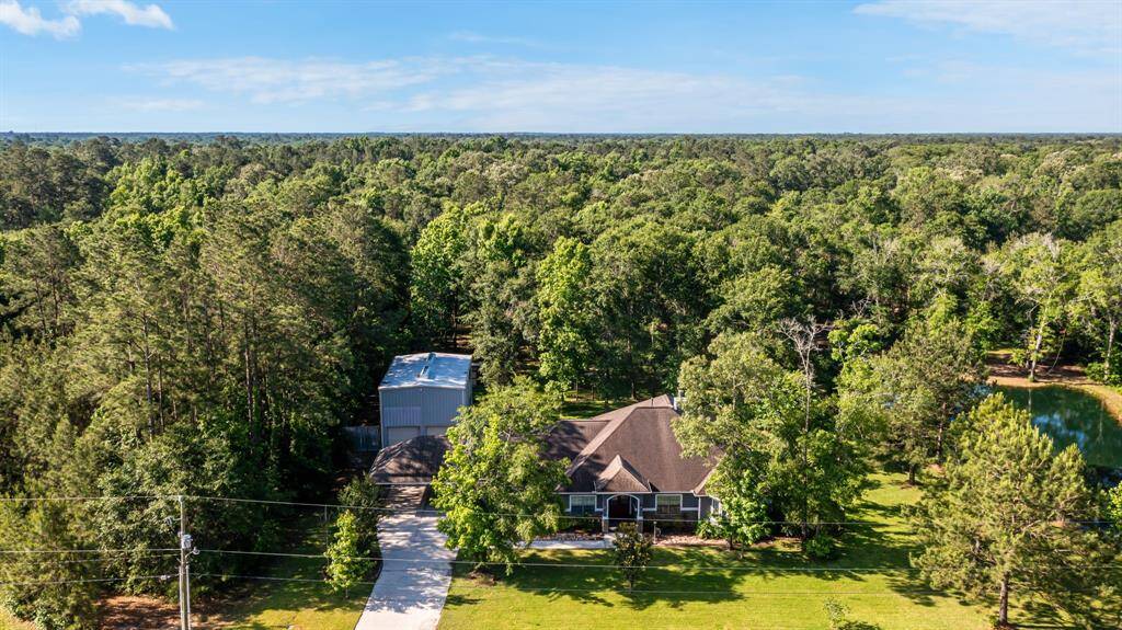 This aerial view reveals the home nestled among lush trees, blending privacy with natural beauty across 3.68 acres.