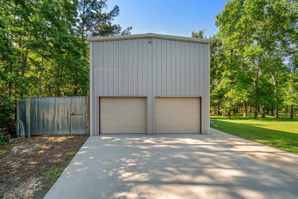 The oversized garage/workshop boasts a wide, smooth driveway and impressive scale—perfect for hobbies, storage, or creative projects.