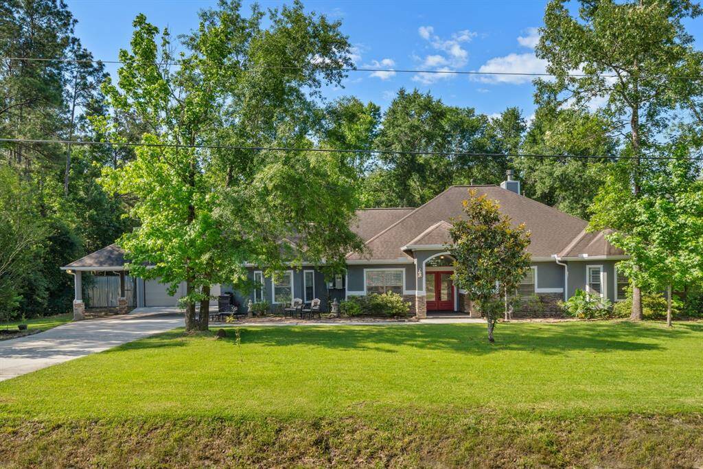 In full daylight, the front of the home is framed by a sprawling green lawn and mature trees, creating a picture-perfect first impression.