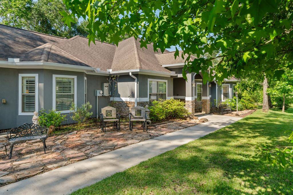 This angled view showcases outdoor seating, plant beds, and a well-kept yard—thoughtfully arranged for curb appeal.