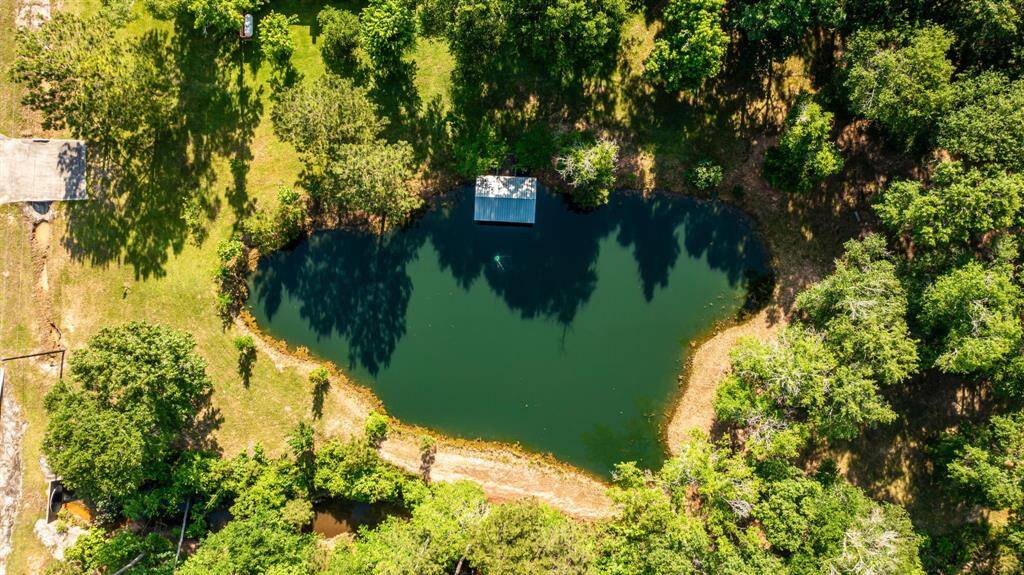 From above, the pier extends into the tree-rimmed pond, underscoring the natural allure of this tucked-away retreat.