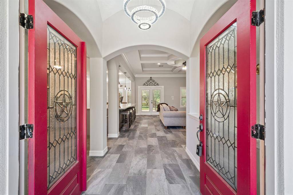 A dazzling chandelier crowns the grand foyer, which leads directly into the home’s central living spaces.