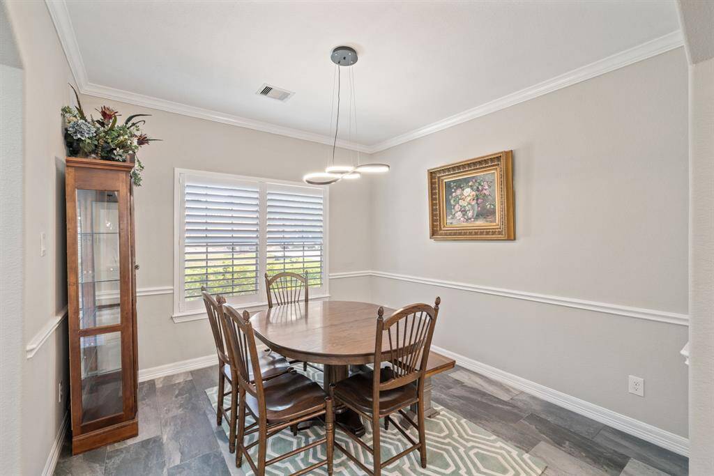 Bathed in daylight from a generous window, this dining space feels both open and intimate, perfect for hosting.
