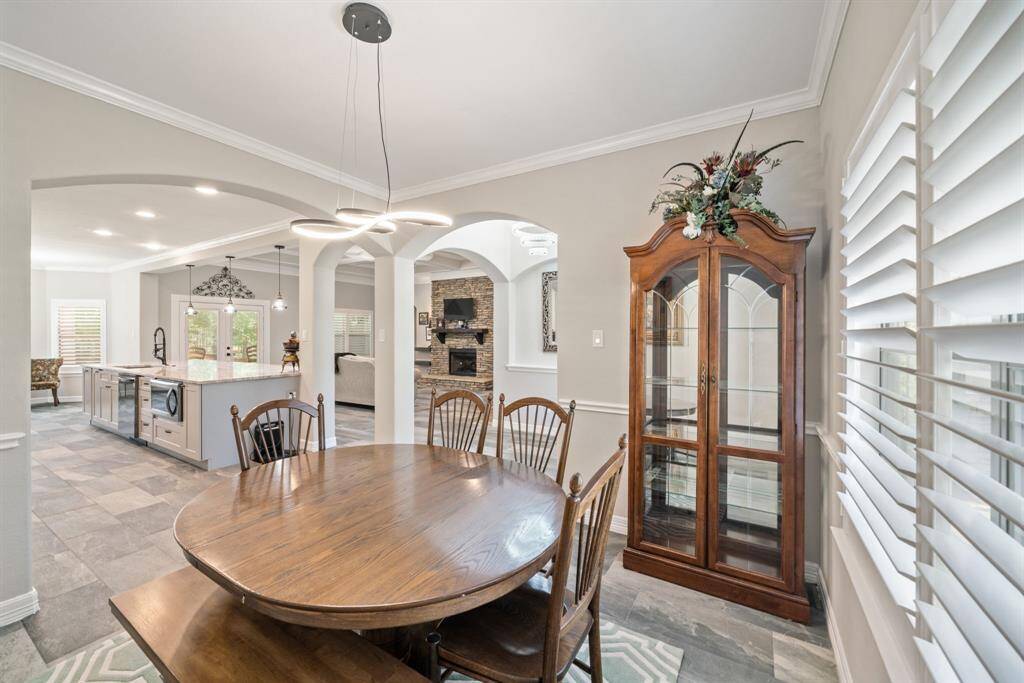 The dining area flows seamlessly under wide archways and overlooks the main living area.