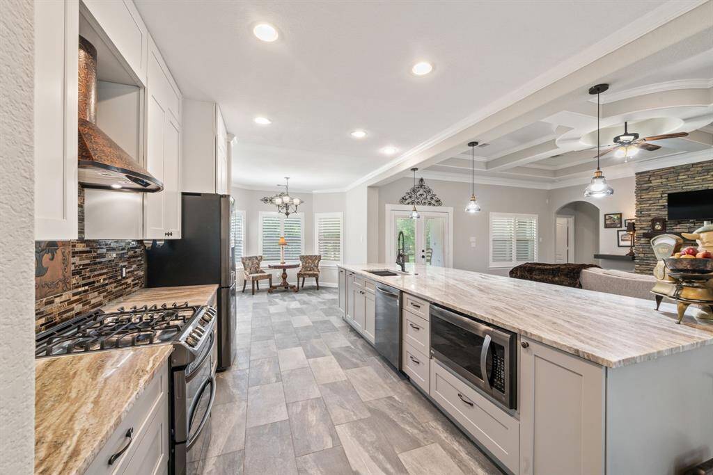 The gourmet kitchen is anchored by a vast granite island and offers seamless connectivity to the living room—ideal for gathering and entertaining.