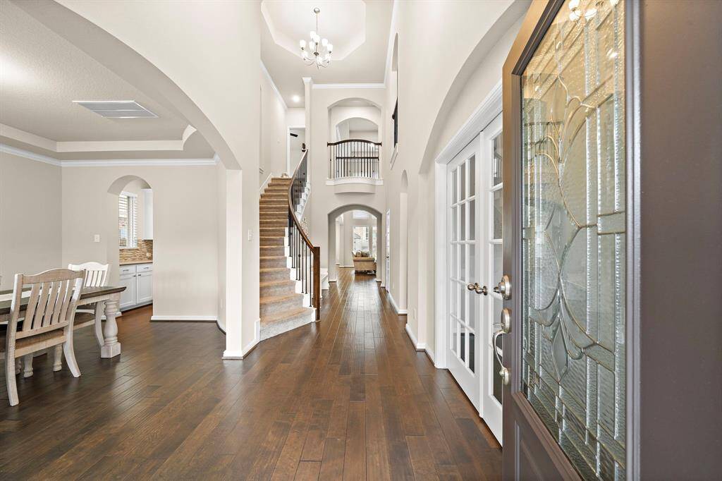 As you walk inside you are greeted with engineered hardwood floors, tall ceilings, and a curved staircase.