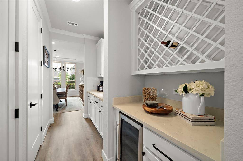 Double butler's pantry located in between the formal dinging room and kitchen.  This particular area features a wine refrigerator, wine storage, and cabinet space.
