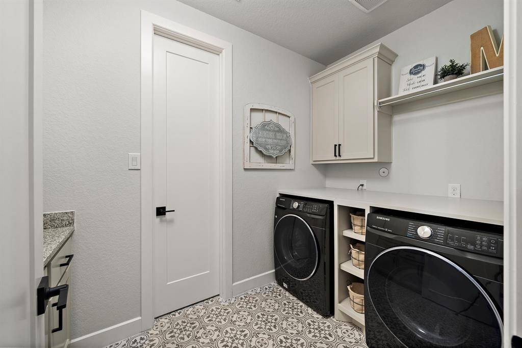 Laundry room located on the first floor features 2 seperate counter area, cabinets, and a hanging rack.