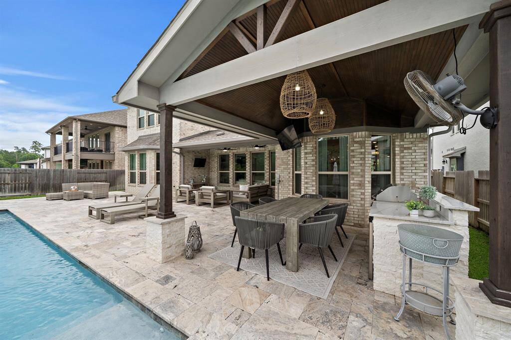 The backyard also includes a seperate covered patio area, outdoor kitchen, and custom lighting.
