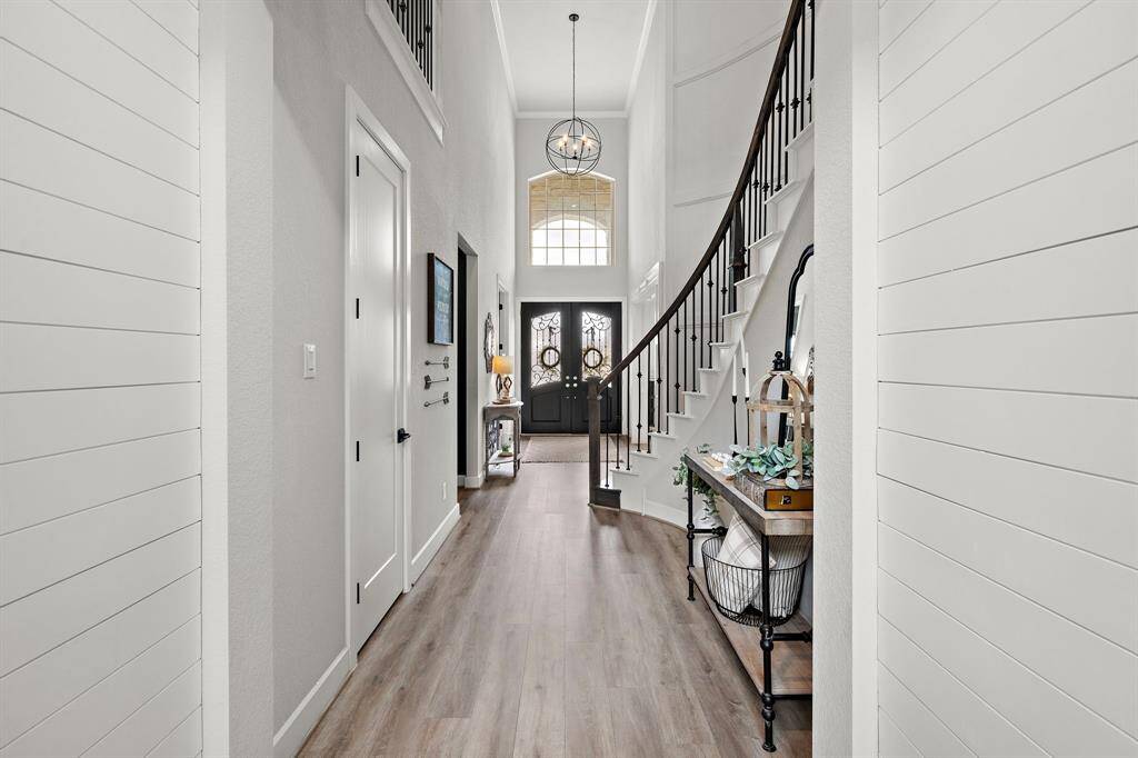 A look back at the entrway feautring tall ceilings, crown molding and custom shiplap walls.
