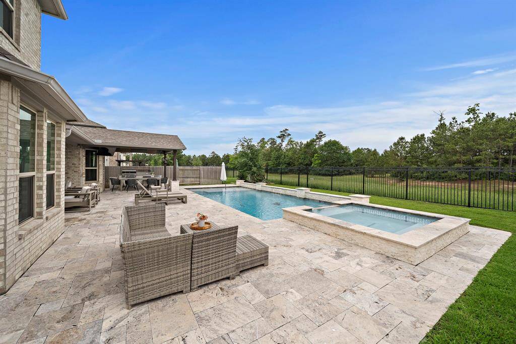Beautiful travertine surrounds the entire pool and backyard patios and lounging areas.