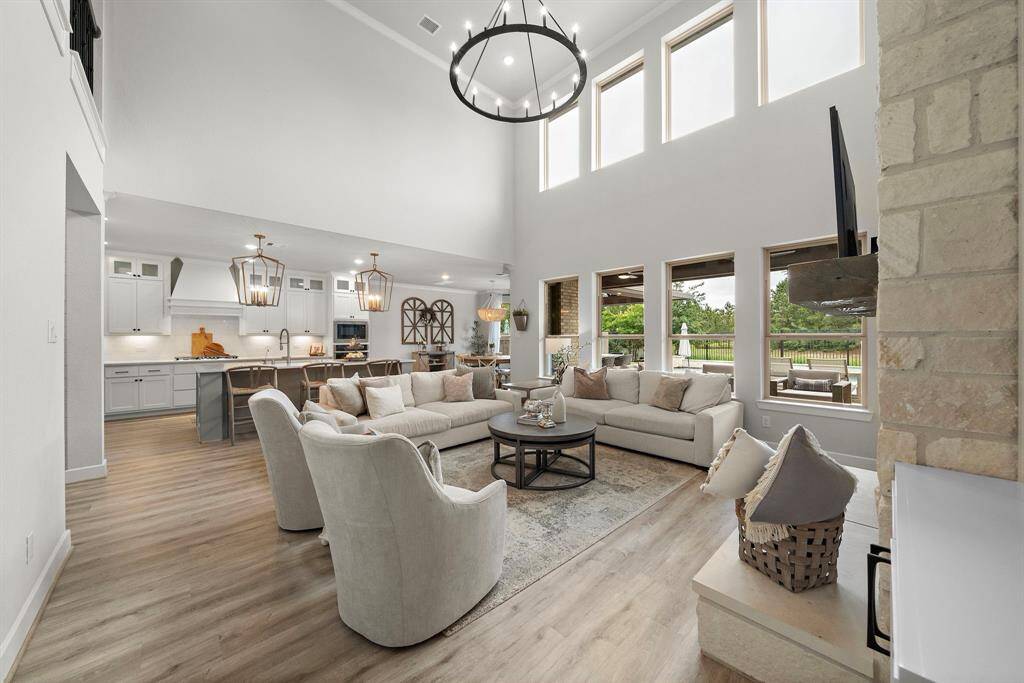 Pefect open living room featuring a wall of windows to allow for natural light and a custom chandelier.