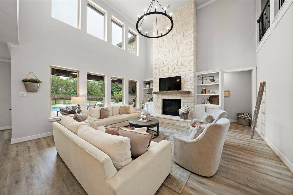 The living room features a stone accent wall for the gaslog fireplace and custom built-in shelving.