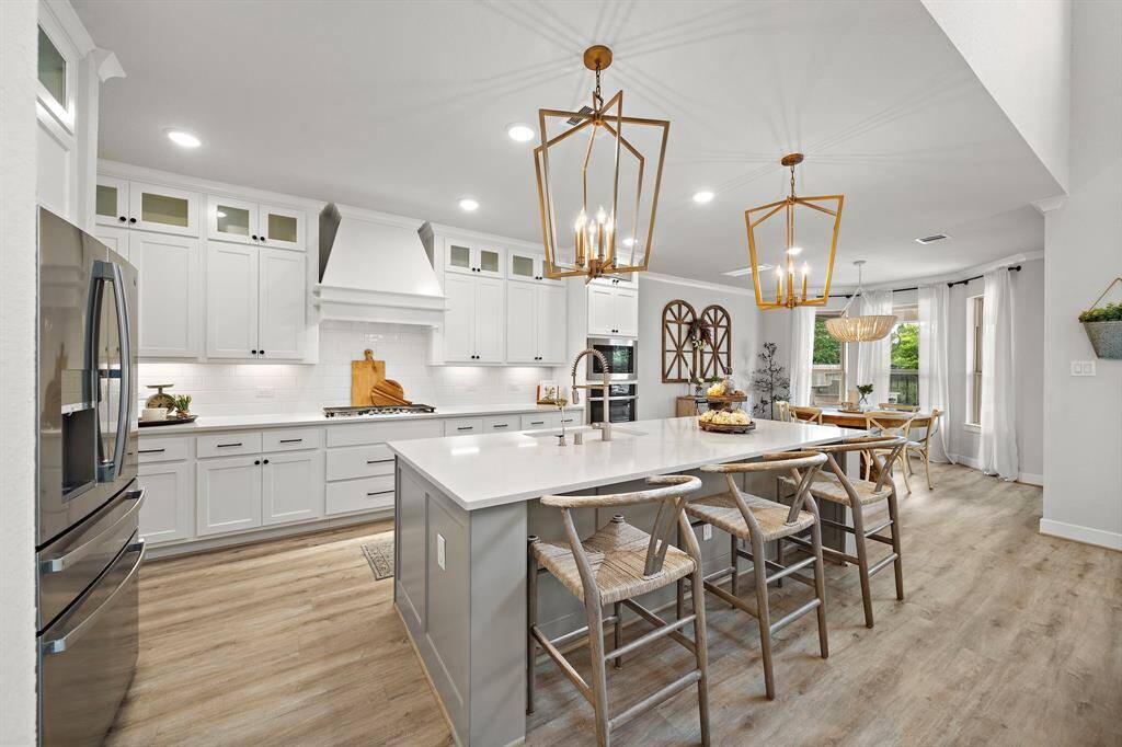 The gourmet kitchen has it all! Upgraded top cabinets with glass inserts, upgraded pendant lighting, large kitchen island with a breakfast bar for extra seating.