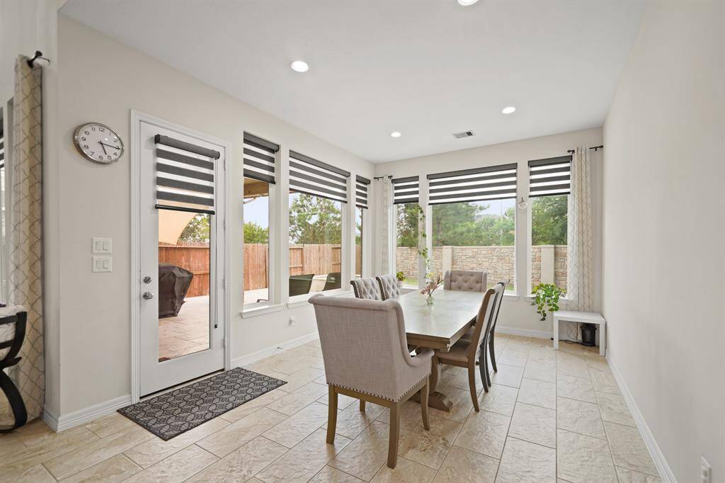 Spacious dining area with tile floors, recessed lighting, and large windows with views into your backyard.