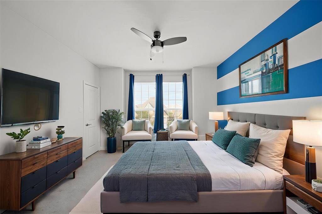 Virtually Staged: Large secondary bedroom with carpet floors, a ceiling fan, and windows with privacy blinds.