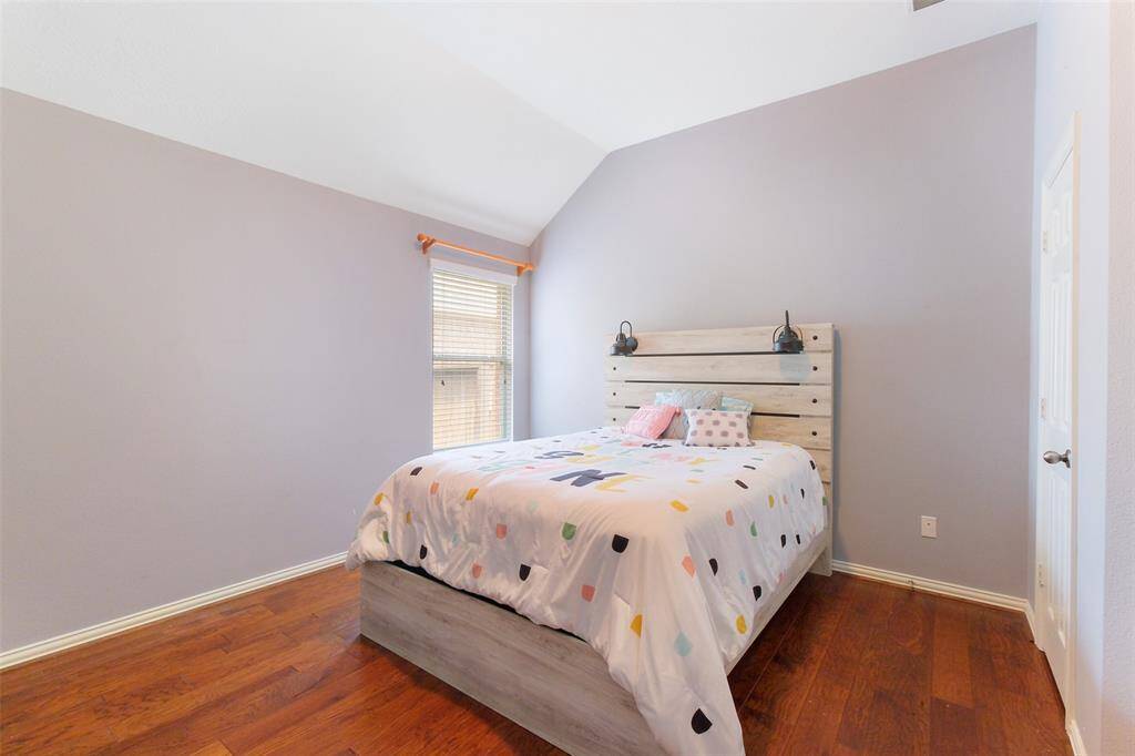 Another secondary bedroom is located on the first floor, featuring engineered wood flooring, a raised ceiling, and a generous closet—perfect for guests, kids, or a flexible space to fit your lifestyle.