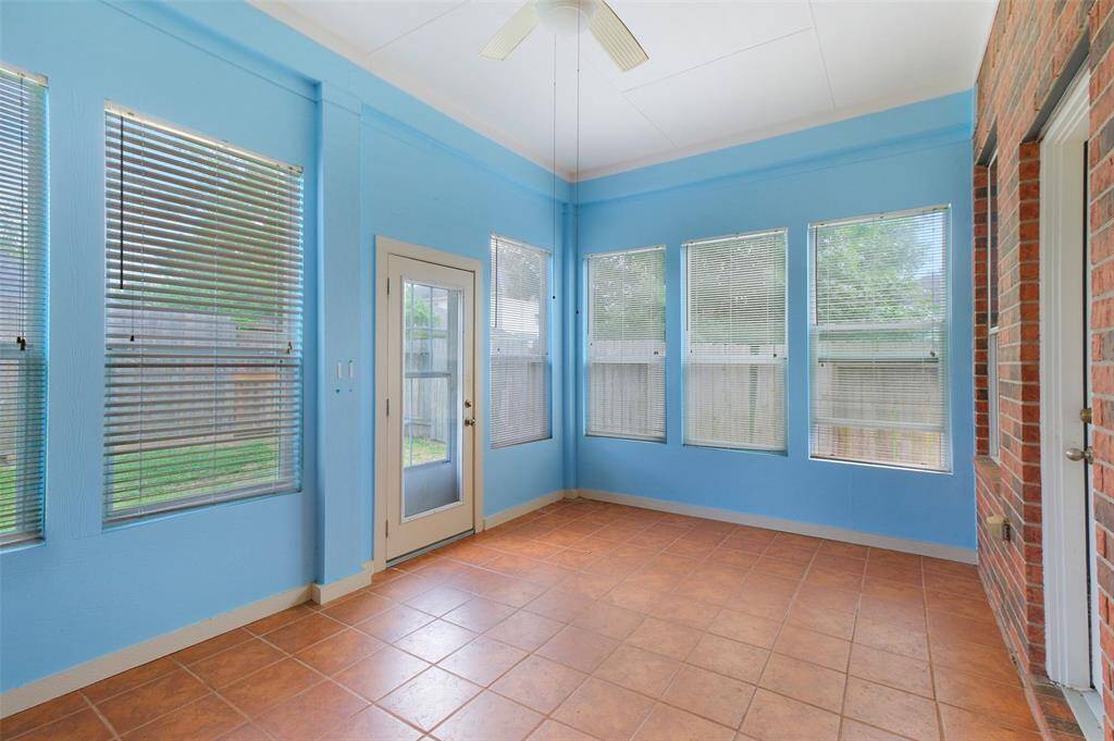 Enjoy pest-free outdoor living in the screened-in porch, complete with tile flooring and a ceiling fan—perfect for morning coffee, evening relaxation, or entertaining in comfort year-round.