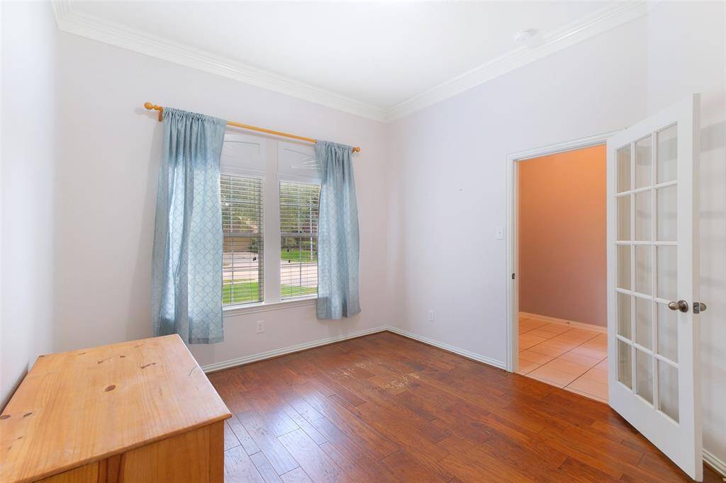 Escape to a private study with glass French doors, crown molding, and rich engineered wood floors—perfect for working from home or creating a quiet reading space. Front-facing windows provide great natural light.