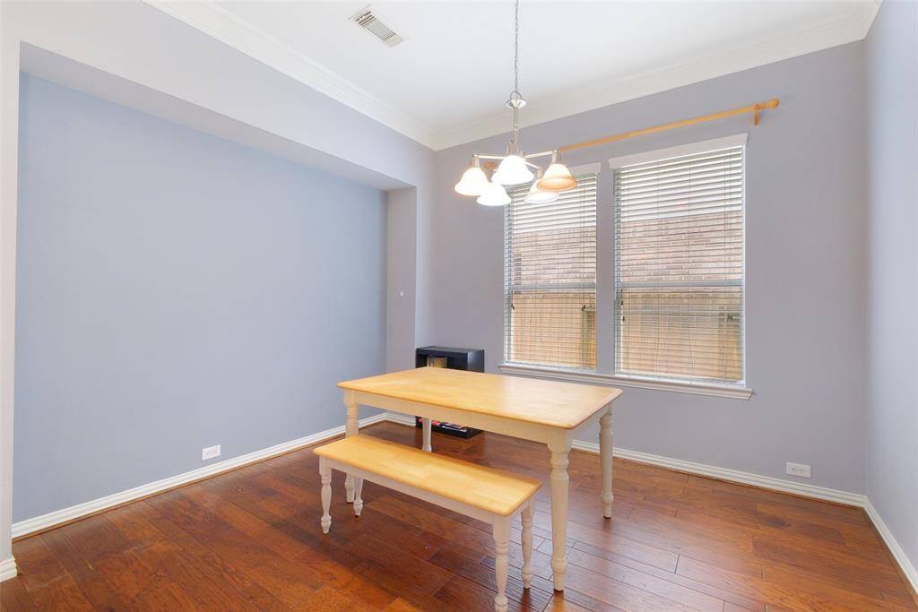 Formal dining room located just beyond the study and off of the foyer, featuring crown molding, rich wood floors, and a recessed accent wall—ideal for hosting dinners or holiday gatherings.