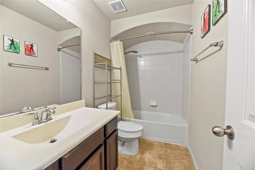 The upstairs full bath is beautifully appointed with contemporary fixtures and spacious design, offering a perfect blend of functionality and relaxation for both family and guests.