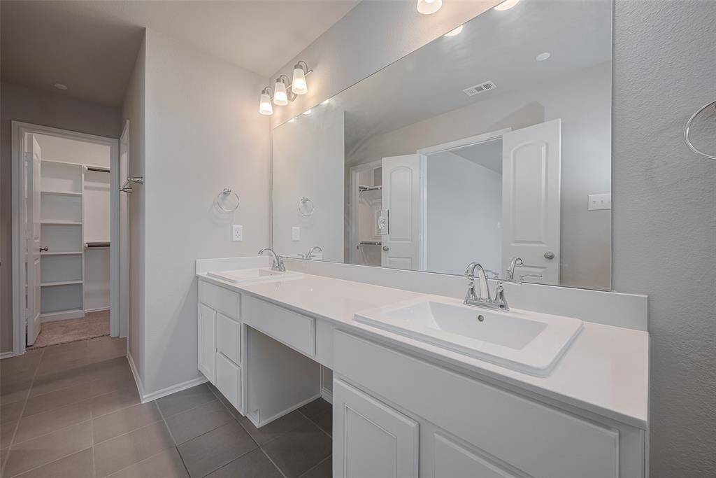 Here’s another view of the primary bath—featuring not one, but two spacious closets for added convenience and storage!