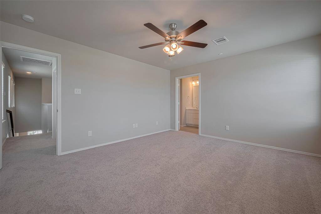 The primary bedroom is located just off the stairwell and offers added privacy, thoughtfully set across the game room from the other bedrooms. It features its own en-suite bath with double vanities, stylish finishes, and two spacious closets for ultimate convenience.