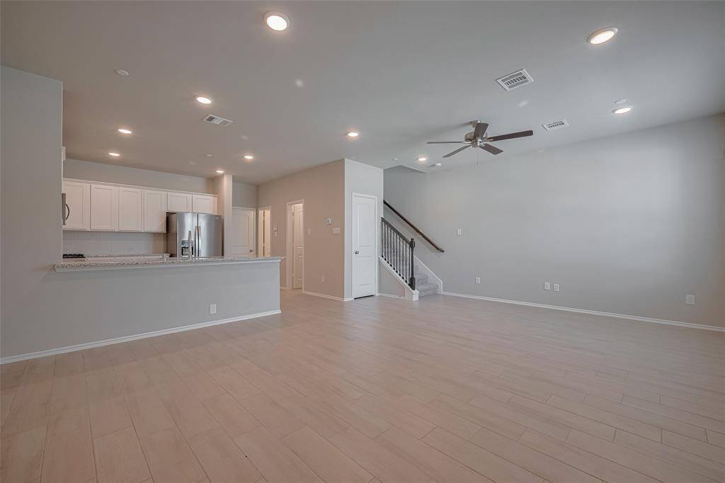As you enter the home, you're welcomed by an open-concept living and dining area featuring wood-look tile flooring throughout the first floor. A spacious walk-in pantry offers ample storage, and a convenient half bath completes the main level.