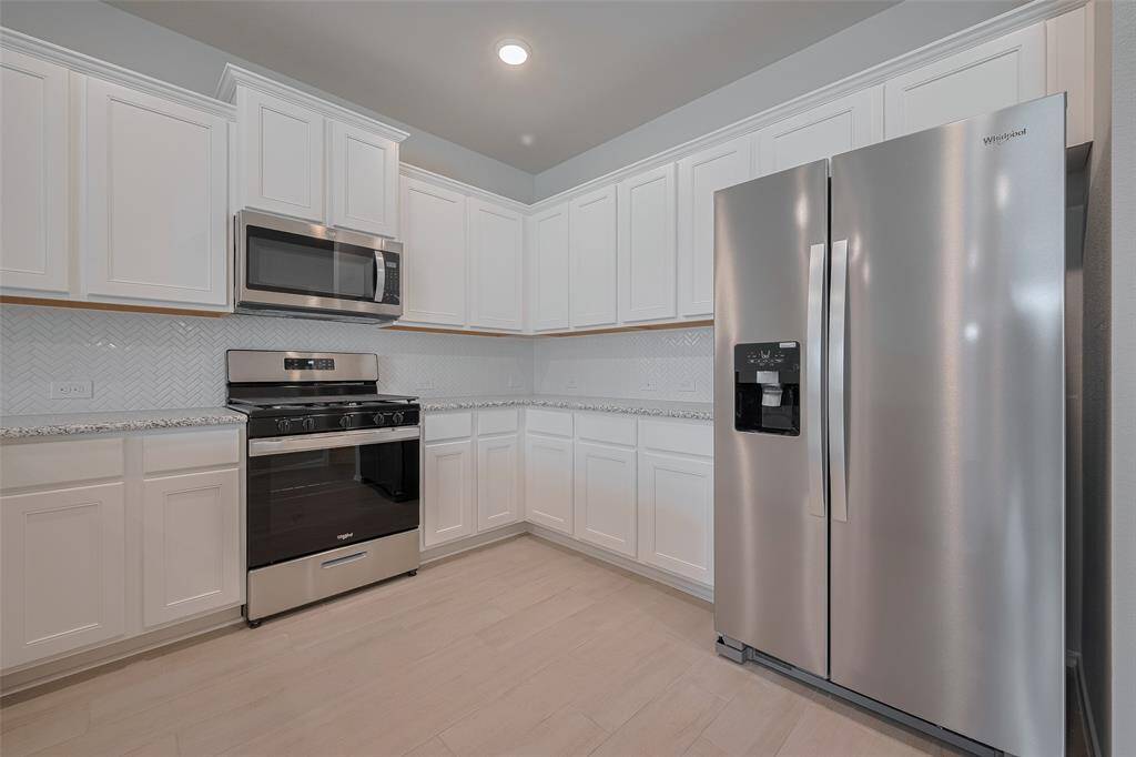 The kitchen boasts pristine white cabinetry and an abundance of cabinet space, offering both elegance and exceptional storage.