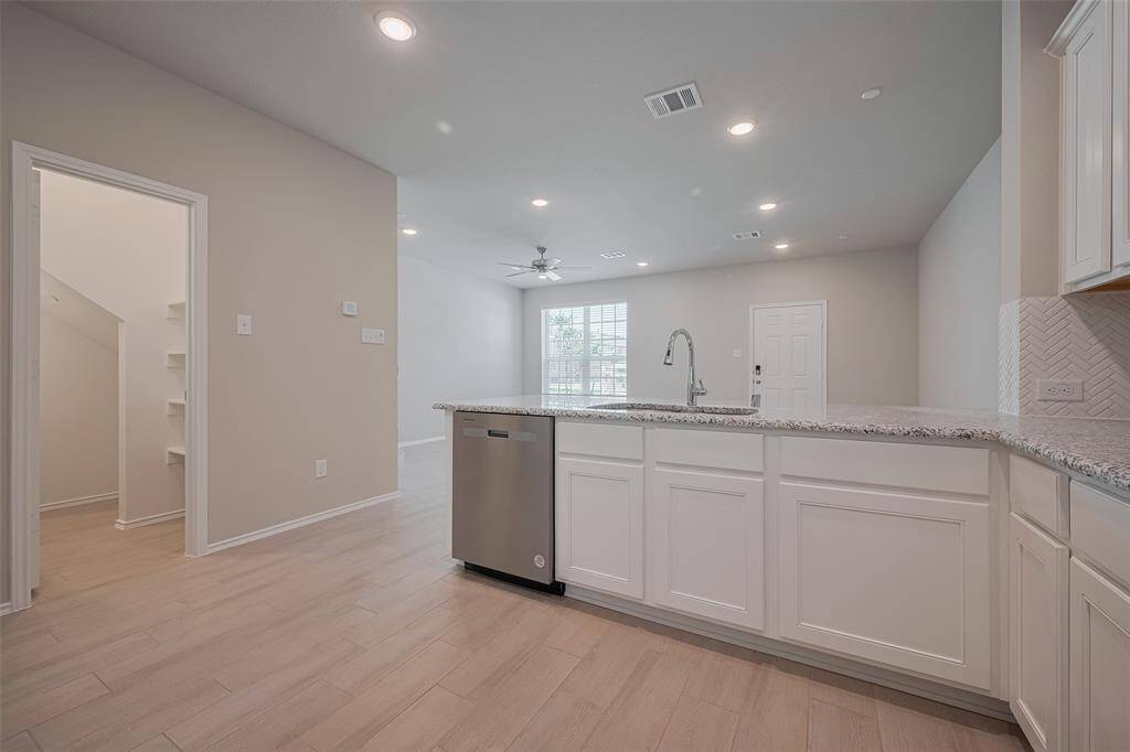 Looking back from the open kitchen, you’ll notice how bright, airy, and inviting the entire living space feels. There’s even a bar area, perfect for barstools and additional eating space.