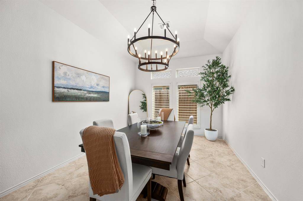 Large dining room with rustic farmhouse custom chandelier and custom plantation shutters.