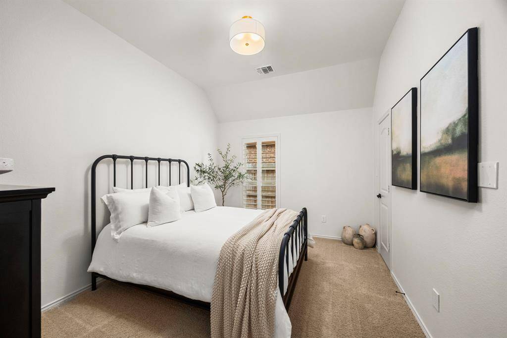 Secondary bedroom features custom barn door with stylish new black hardware, high ceilings and custom plantation shutters. Bedroom has a connecting hallway to Jack & Jill bath adjacent to office flex room.