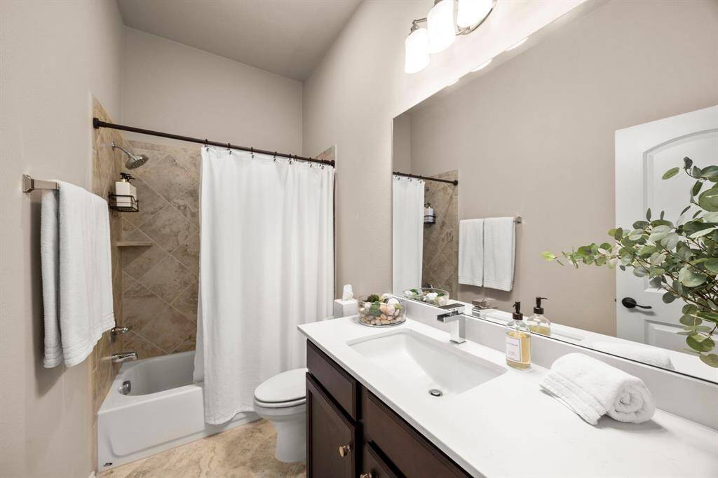 Modern private bath with custom tile flooring and tile shower/tub combo. Ultra sleek countertops and faucet.