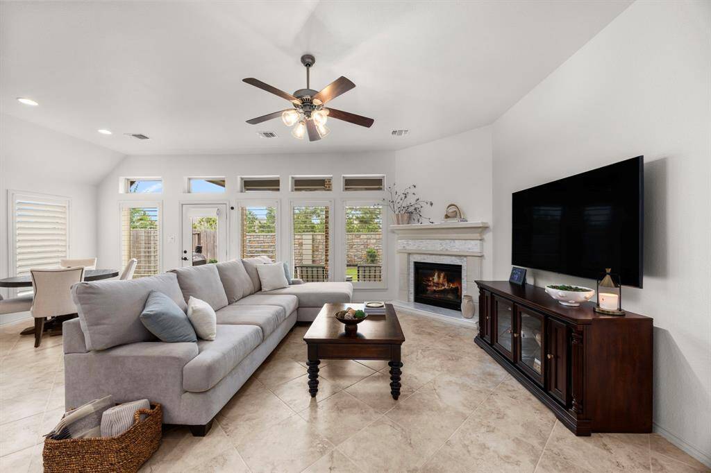 Ultra cozy family room with stone fireplace and remote gas log perfect for cold winters. Nice high ceilings, custom plantation shutters and beautiful tile flooring throughout.