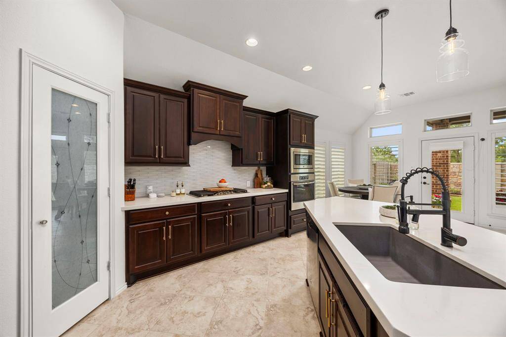Farmhouse granite sink, quartz countertops, oversized pantry, all new cabinet hardware & modern pendant lighting.
