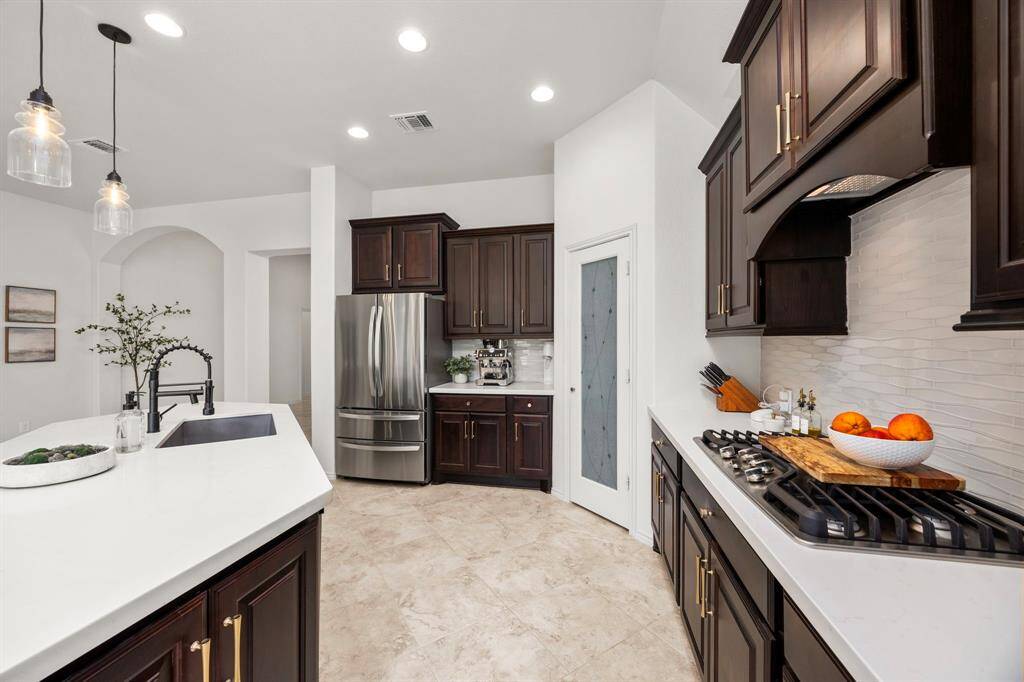 Custom backsplash, beautiful cabinetry, lots of storage, ample counterspace and ultra sleek quartz countertops.
