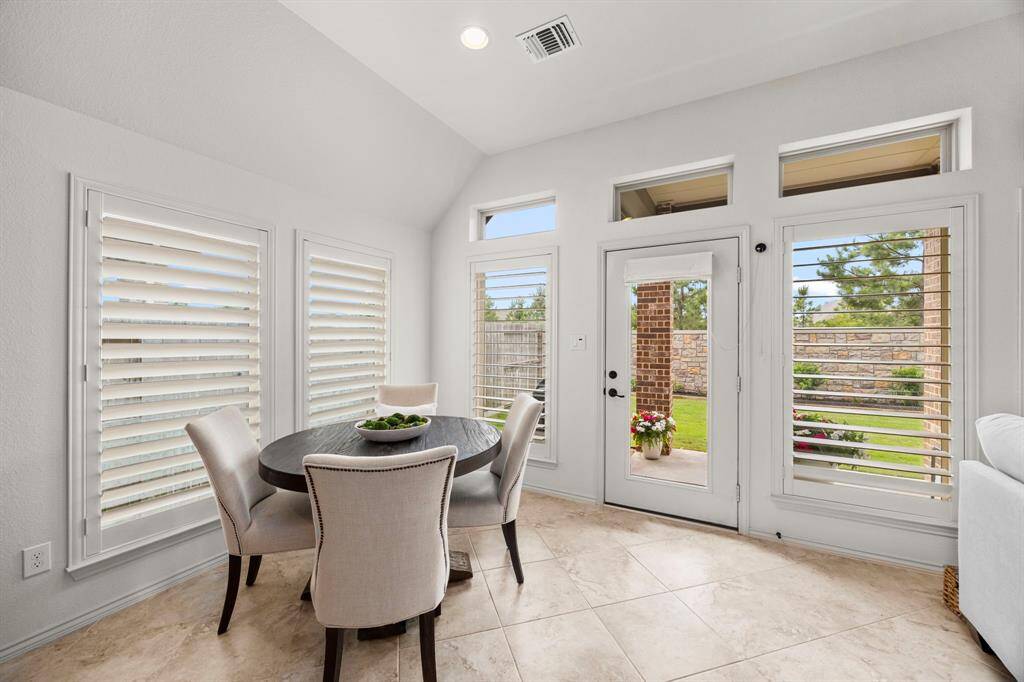 Cozy breakfast nook looking out to patio with large windows, custom plantation shutters and recessed lighting. Perfect for light morning meals and coffee.