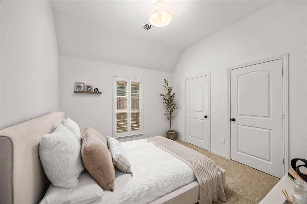 Private secondary bedroom with high ceilings and custom plantation shutters with personal full bath in hallway perfect for guest.